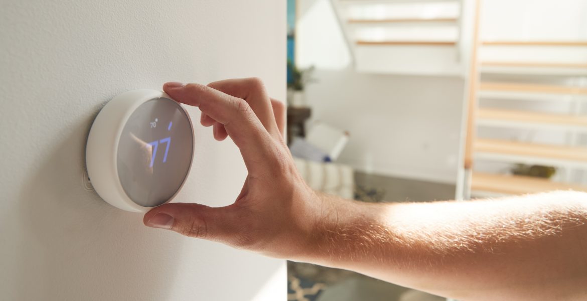 http://Homeowner%20adjusting%20settings%20on%20a%20modern%20smart%20thermostat%20to%20control%20indoor%20temperature%20and%20save%20energy.